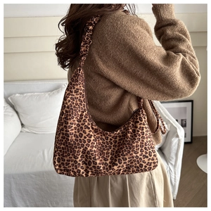 Detail of leopard print hobo bag showing the ruched shoulder strap and fabric texture