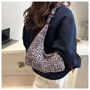 Detailed back view of a leopard print hobo bag featuring ruffled canvas shoulder straps