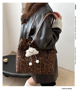 Detail of vintage leopard print tote bag with brown straps and white cloud charm