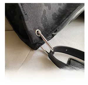 Vue macro détaillée du cabas noir avec des ferrures en argent et une bandoulière en cuir noir