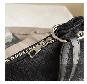 Gros plan sur la fermeture éclair argentée et la texture en dentelle noire du sac