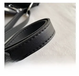 Vue détaillée de la bandoulière en cuir noir avec coutures renforcées et anneau métallique
