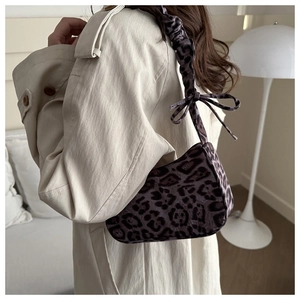 Borsa leopardata sottobraccio con tracolla a pieghe e fiocco su trench beige