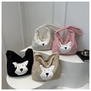 Detailed view of four quilted tote bags with fuzzy dog embroidery on minimalist steps