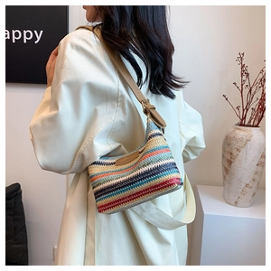 Close-up of a colorful striped woven shoulder bag with a brown leather strap and buckle