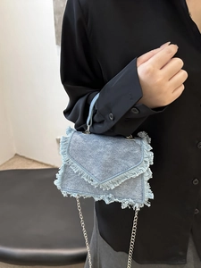 Light blue denim crossbody bag with fringe edges and silver chain strap for women