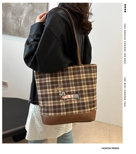 Close-up of vintage brown plaid tote bag with dachshund embroidery and leather trim