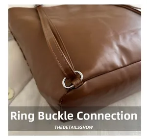 Detail of silver metal ring and strap stitching on brown leather dachshund tote bag