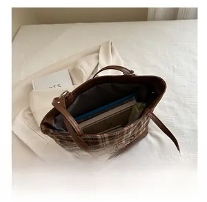 Macro view of plaid tote bag interior showing large capacity and embroidered pattern