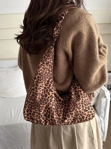 Sac à bandoulière hobo élégant avec imprimé léopard pour femme porté par un mannequin