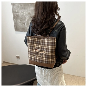 Detail view of plaid tote bag featuring a cute dachshund print and premium brown leather base