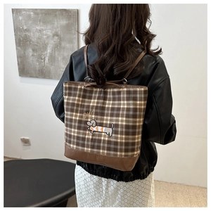 Detail of vintage plaid tote bag featuring dachshund embroidery and leather base