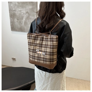 Detail of checkered tote bag featuring a cute dachshund embroidery and brown PU leather base