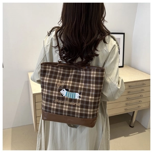 Detail of dachshund embroidery on brown checkered tote bag with leather拼接 and stitching