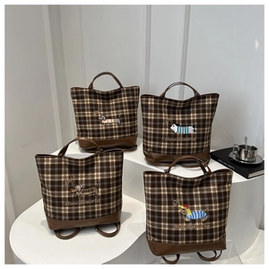 Close-up of vintage plaid bucket bags with cute puppy embroidery and leather details