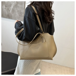 Détail d'un grand sac cabas beige et café avec poche frontale gaufrée et bandoulière