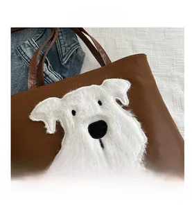Close-up of brown faux leather tote bag with white plush dog patch and smooth handles