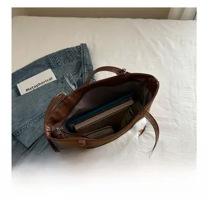 Brown PU leather tote bag with white plush trim showing interior storage capacity