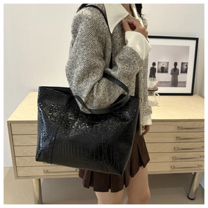 Détail du sac cabas noir motif crocodile avec texture brillante et grande capacité