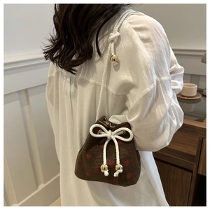 Detail of corduroy bucket bag with strawberry embroidery and thick cotton rope strap