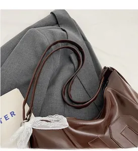 Detail of brown leather tote featuring geometric texture and white lace bow decoration