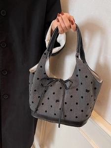 Schicke graue Tote-Bag mit Fischgrätenmuster, schwarzen Punkten und Ledergriffen am Model