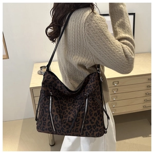 Detalle de bolso hobo de leopardo con cremalleras verticales y flecos largos