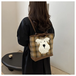 Detailed back view of a plaid tote bag with cute dog patch and brown leather straps