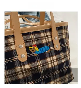 Detail der karierten Beuteltasche mit süßer Hunde-Stickerei und Ledergriff-Akzent