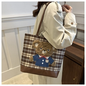 Detail view of brown plaid tote bag featuring a 3D plush teddy bear patch embroidery