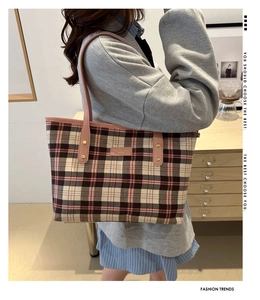 Detail of vintage plaid tote bag featuring pink leather strap and gold metal rivets