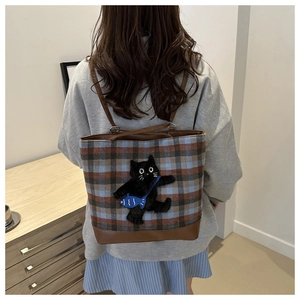 Détail du sac cabas à carreaux avec broderie chat noir et bandoulières en cuir marron