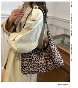 Close-up of leopard print shoulder bag worn with light trench coat on side view
