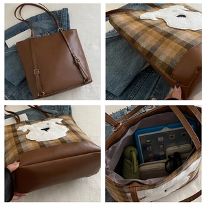 Detail view of plaid tote bag featuring leather trim and spacious interior storage