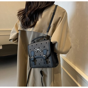 Close-up of ballet-style backpack with silver bow buckle and polka dot embroidery details