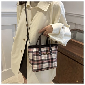 Detail der karierten Handtasche mit süßer Welpenstickerei und Ledergriffen