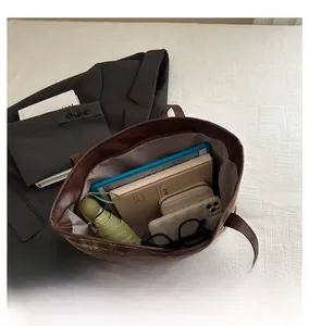 Top view of spacious interior of brown checkered tote bag with daily essentials inside