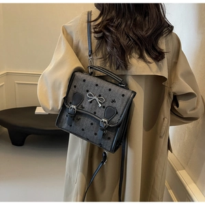Detail of dark grey polka dot bag with mini bow embroidery and silver metal bow buckle