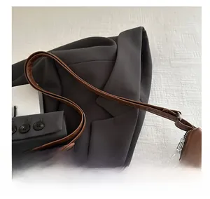 Detail der dunkelbraunen Leder-Umhängetasche mit Metallreißverschluss und glattem Gurt