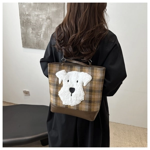 Dettaglio della borsa tote a quadri con patch schnauzer e base in pelle marrone