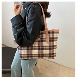 Detailed view of plaid tote bag in pink and black with premium leather straps