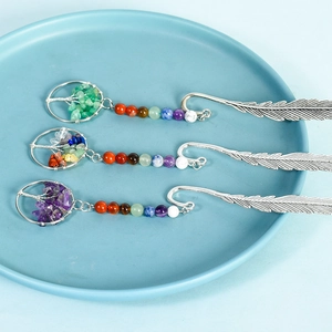 Three silver feather bookmarks with colorful crystal tree of life pendants in a ceramic bowl