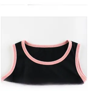 Detail of pink trim and precise stitching on a black sleeveless cotton dress for girls