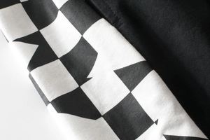 Gros plan détaillé d'un short d'été avec motif en damier noir et blanc et tissu en maille uni