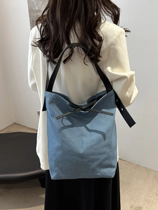 Large capacity denim bucket tote bag with black leather straps and bow detail