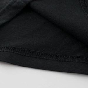 Detail of double-needle stitching on the hem of a black cotton girl's princess dress