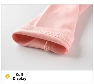 Détail du poignet en coton tricoté rose avec coutures soignées sur un t-shirt fille