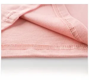 Détail de l'ourlet du t-shirt rose avec double surpiqûre et texture en maille douce