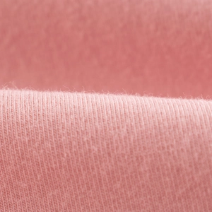Pink knit cotton fabric detail of girls' summer leggings showing soft texture and weave