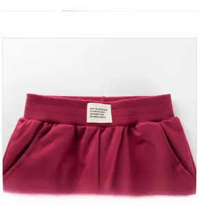 Close-up of girls burgundy joggers showing elastic ribbed waistband and woven label